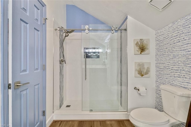 full bath featuring vaulted ceiling, toilet, a shower stall, and wood finished floors