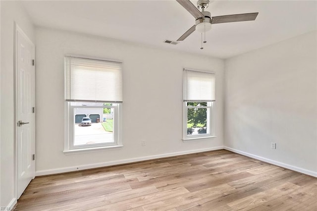 spare room featuring light wood finished floors, ceiling fan, and baseboards