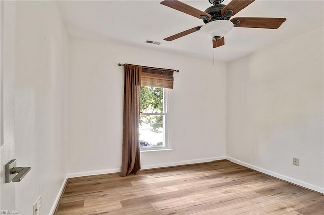 spare room featuring light wood finished floors, ceiling fan, and baseboards