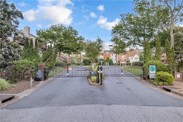 242 Genoa Dr Unit 20, Hampton, VA 23664 - view of asphalt road with a gate, a gated entry, curbs, and a residential view
