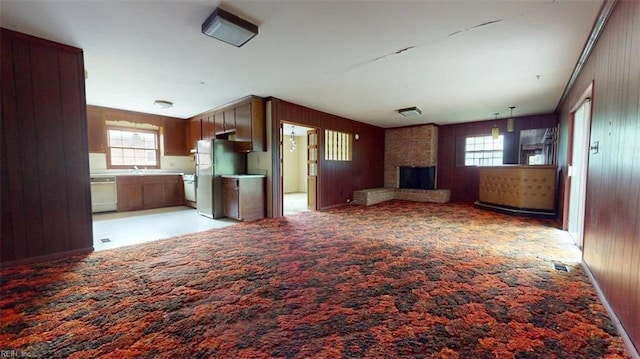 1030 Mary Peake Blvd, Hampton, VA 23666 - unfurnished living room featuring wood walls, a fireplace, light colored carpet, and a sink