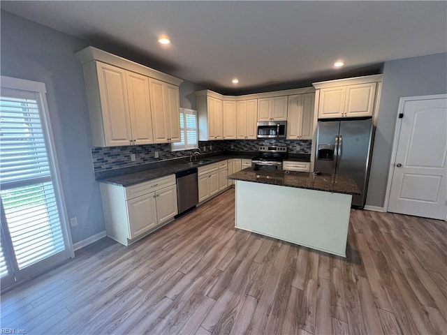 405 San Antonio Blvd, Norfolk, VA 23505 - kitchen featuring appliances with stainless steel finishes, tasteful backsplash, light wood-style floors, a kitchen island, and white cabinets