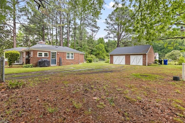 6944 Crittenden Rd, Suffolk, VA 23432 - view of grassy yard with a garage and an outbuilding