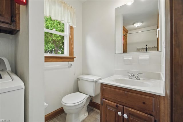 1121 Vineyard Dr, Chesapeake, VA 23322 - bathroom with washer / clothes dryer, toilet, vanity, wood finished floors, and baseboards