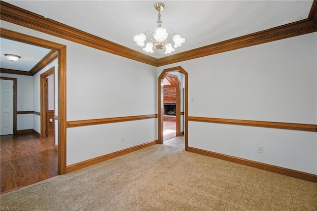 1121 Vineyard Dr, Chesapeake, VA 23322 - empty room featuring crown molding, a chandelier, arched walkways, baseboards, and carpet flooring