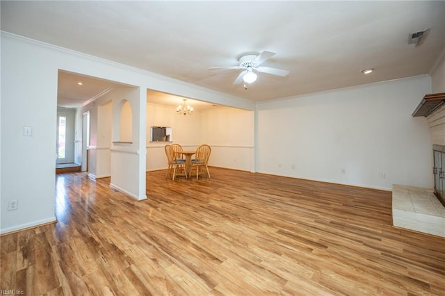 1217 Peoples Way, Virginia Beach, VA 23451 - unfurnished living room featuring crown molding, light wood-type flooring, a chandelier, a brick fireplace, and a ceiling fan