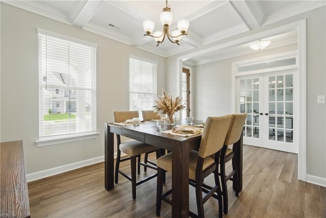 1028 Egret Ln, Suffolk, VA 23434 - dining space with coffered ceiling, a chandelier, french doors, plenty of natural light, and wood finished floors