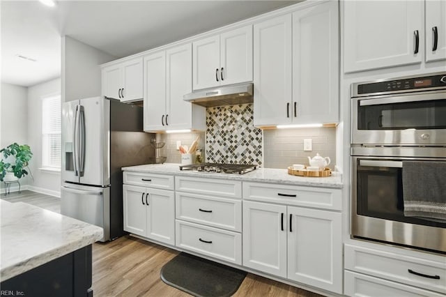 1028 Egret Ln, Suffolk, VA 23434 - kitchen with appliances with stainless steel finishes, under cabinet range hood, white cabinetry, and light wood finished floors