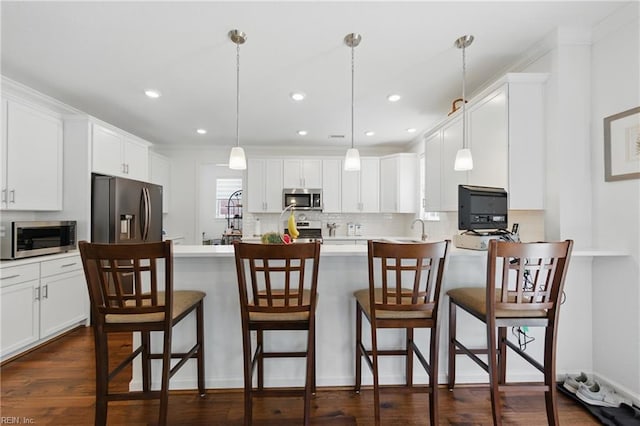 605 Middleton Way, Chesapeake, VA 23322 - kitchen featuring stainless steel appliances, decorative backsplash, white cabinets, a breakfast bar, and recessed lighting