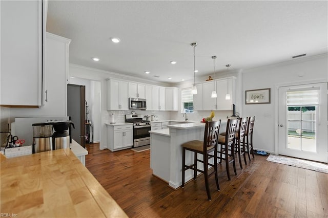 605 Middleton Way, Chesapeake, VA 23322 - kitchen with stainless steel appliances, light countertops, a sink, ornamental molding, and a breakfast bar area