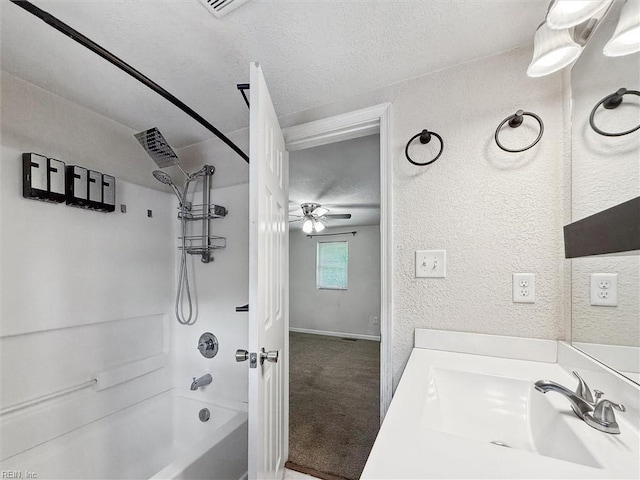 full bath with ceiling fan, a textured wall,  shower combination, vanity, and a textured ceiling