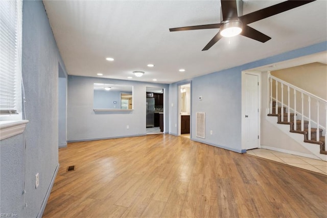 unfurnished living room featuring stairs, ceiling fan, wood finished floors, recessed lighting, and baseboards