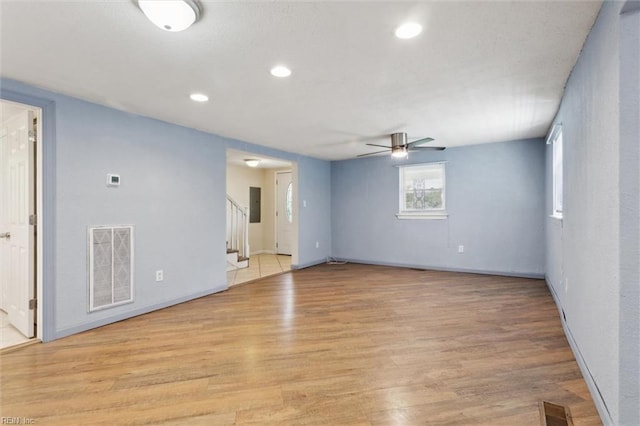 spare room featuring ceiling fan, stairs, light wood finished floors, recessed lighting, and baseboards