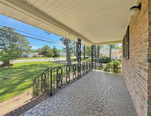 covered porch featuring a lawn