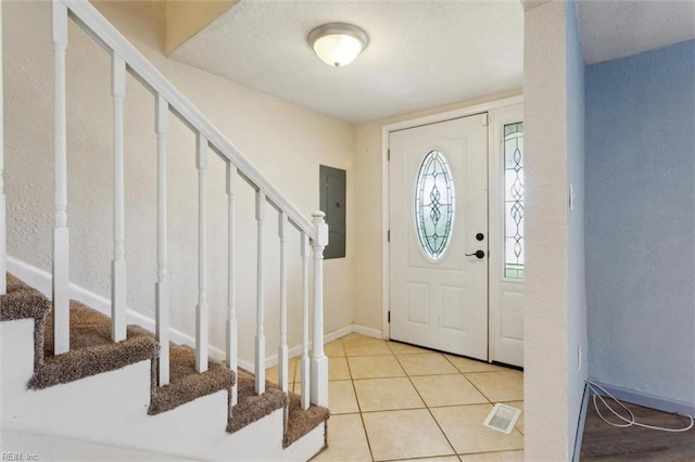 foyer with stairs, electric panel, tile patterned floors, and baseboards