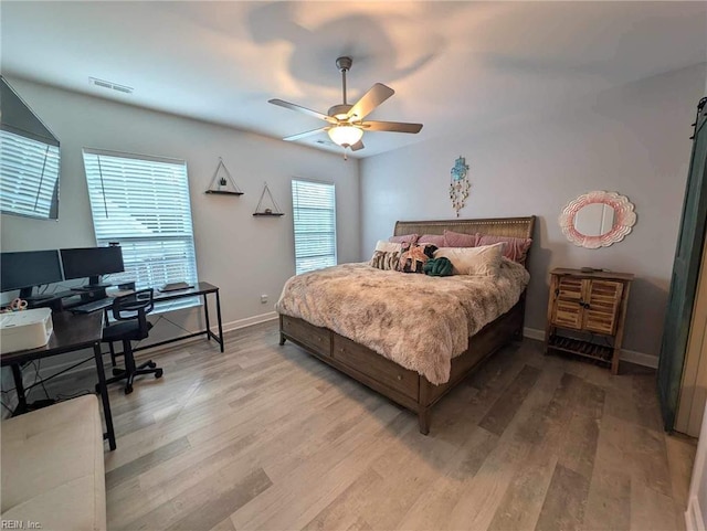 bedroom featuring a desk, wood finished floors, baseboards, and a ceiling fan