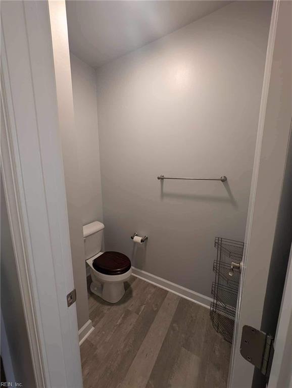 bathroom featuring wood finished floors, toilet, and baseboards
