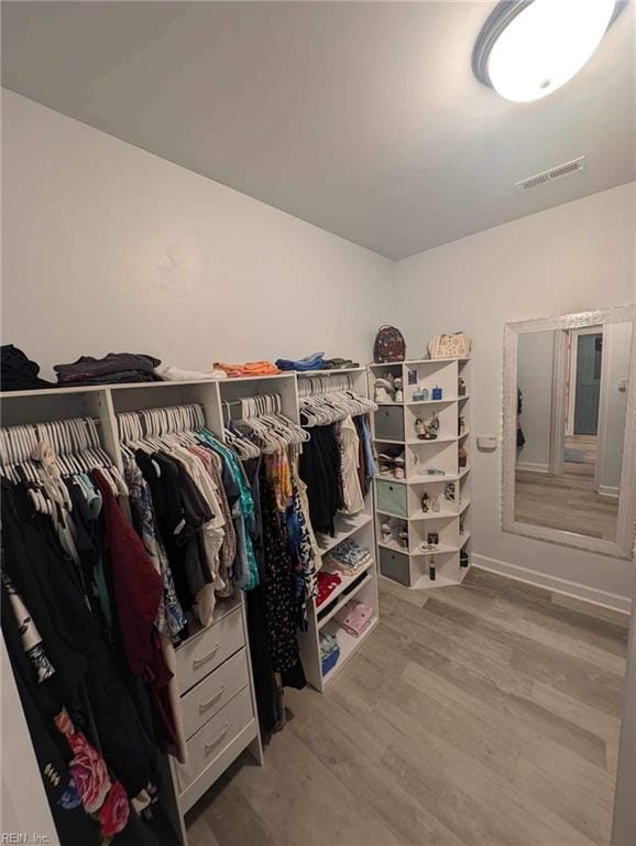 walk in closet with wood finished floors