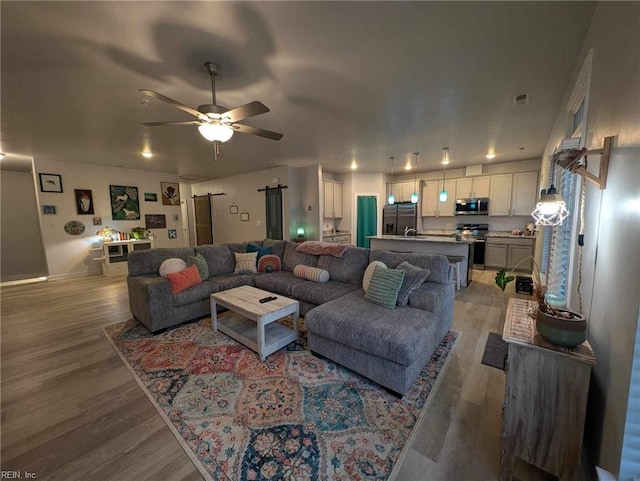 living room featuring light wood-type flooring and ceiling fan