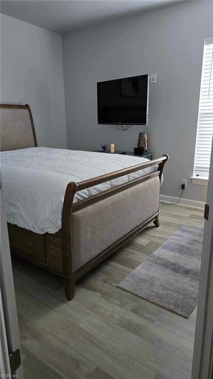 bedroom featuring wood finished floors and baseboards