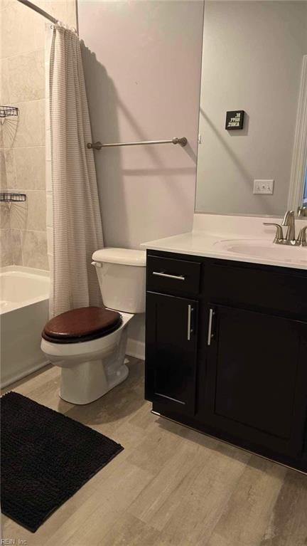 full bathroom featuring toilet, shower / bath combination with curtain, and vanity