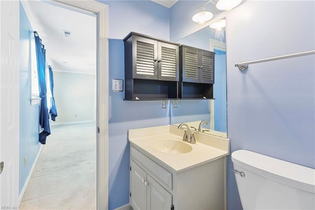 bathroom with toilet, vanity, and baseboards