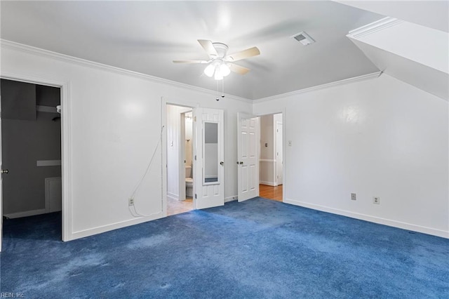 unfurnished bedroom with a walk in closet, carpet, ornamental molding, connected bathroom, and ceiling fan
