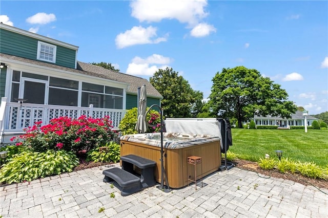 view of patio / terrace featuring a hot tub and a sunroom