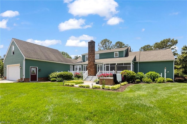 rear view of house featuring a chimney, a sunroom, a lawn, and roof with shingles