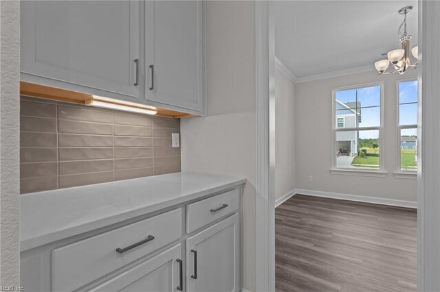 224 Preserve Way, Suffolk, VA 23434 - kitchen with crown molding, a chandelier, tasteful backsplash, light countertops, and dark wood-style flooring