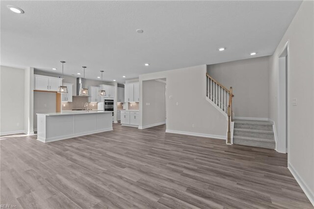 224 Preserve Way, Suffolk, VA 23434 - unfurnished living room featuring recessed lighting, stairs, wood finished floors, a sink, and baseboards