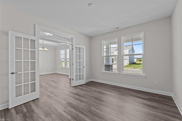 224 Preserve Way, Suffolk, VA 23434 - spare room featuring french doors, a chandelier, dark wood-style floors, and baseboards