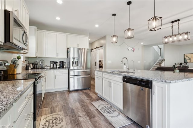 110 Sea Hero Ct, Suffolk, VA 23435 - kitchen featuring appliances with stainless steel finishes, a sink, a barn door, dark wood-style floors, and white cabinets