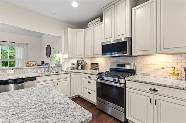304 Michael Selby Dr, Hampton, VA 23666 - kitchen featuring appliances with stainless steel finishes, decorative backsplash, dark wood finished floors, light stone countertops, and white cabinetry