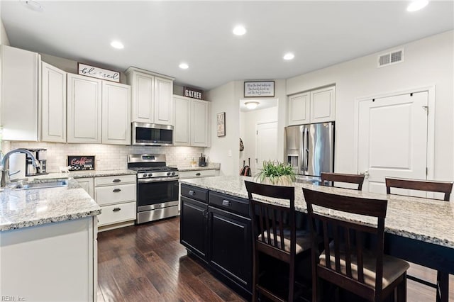 304 Michael Selby Dr, Hampton, VA 23666 - kitchen with stainless steel appliances, a sink, a kitchen breakfast bar, backsplash, and dark wood-type flooring