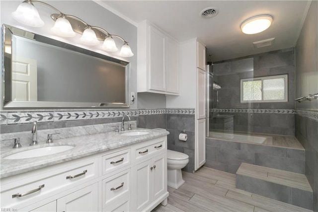101 Stadium Dr, Chesapeake, VA 23322 - bathroom featuring toilet, a tile shower, double vanity, tile walls, and wood finished floors
