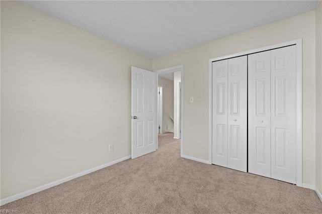 unfurnished bedroom with carpet, baseboards, and a closet