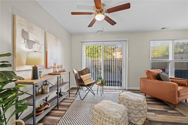 living area featuring plenty of natural light, baseboards, ceiling fan, and wood finished floors