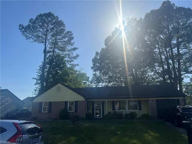 single story home featuring brick siding, an attached garage, and a front lawn