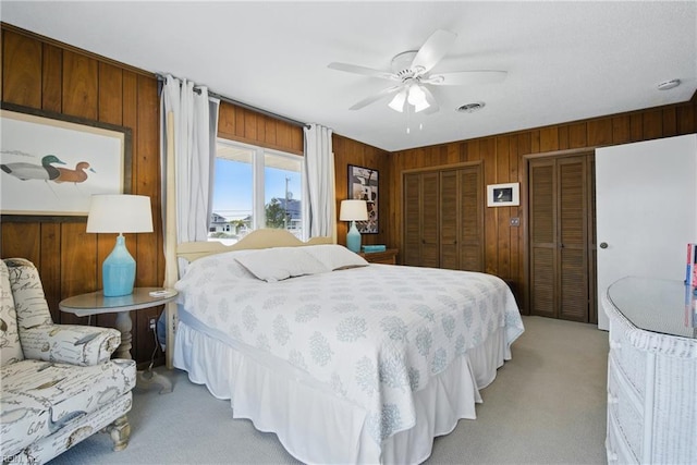 3616 Sandfiddler Rd, Virginia Beach, VA 23456 - bedroom with light colored carpet, multiple closets, wooden walls, and ceiling fan