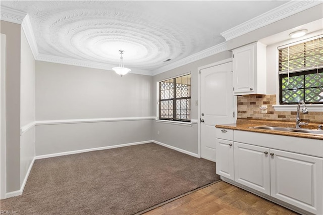 1048 Wilmington St, Norfolk, VA 23505 - kitchen featuring a sink, white cabinets, ornamental molding, decorative backsplash, and light carpet
