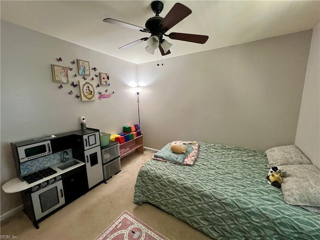 bedroom with light colored carpet, ceiling fan, and baseboards