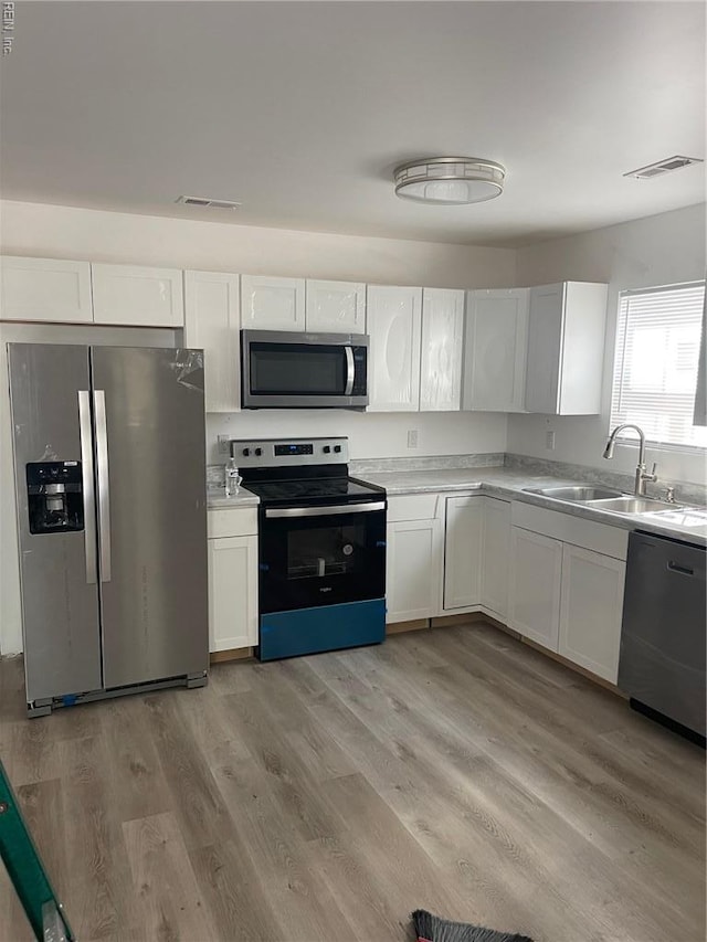 712 Norfleet St, Franklin, VA 23851 - kitchen featuring appliances with stainless steel finishes, a sink, white cabinets, and light countertops