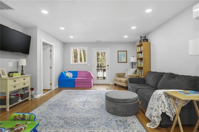 28111 Harbor Rd, Melfa, VA 23410 - living room featuring wood finished floors, recessed lighting, a wall mounted air conditioner, and baseboards