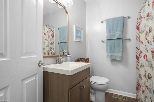 28111 Harbor Rd, Melfa, VA 23410 - full bath with wood finished floors, toilet, vanity, and baseboards