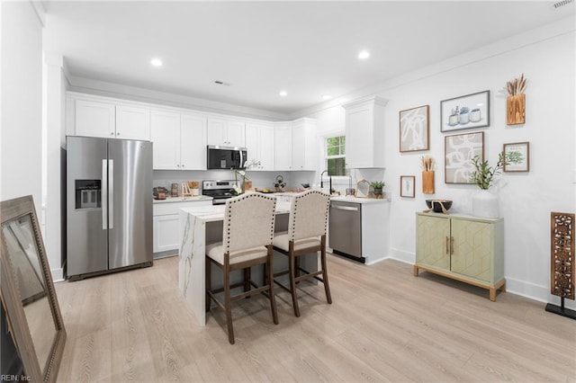 107 Wheeley Cir, Yorktown, VA 23693 - kitchen featuring appliances with stainless steel finishes, white cabinets, light wood-style flooring, light countertops, and recessed lighting