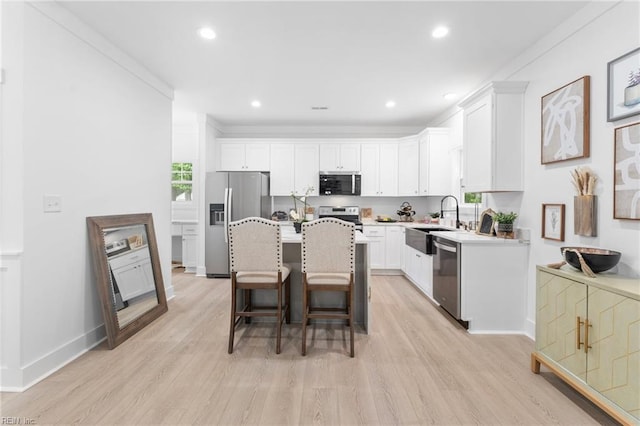 107 Wheeley Cir, Yorktown, VA 23693 - kitchen featuring stainless steel appliances, light wood-type flooring, white cabinets, a breakfast bar area, and a kitchen island