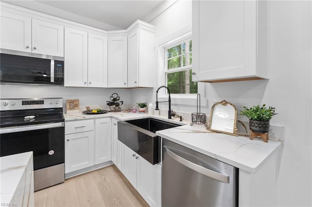 107 Wheeley Cir, Yorktown, VA 23693 - kitchen featuring stainless steel appliances, a sink, white cabinets, light stone countertops, and light wood-style flooring