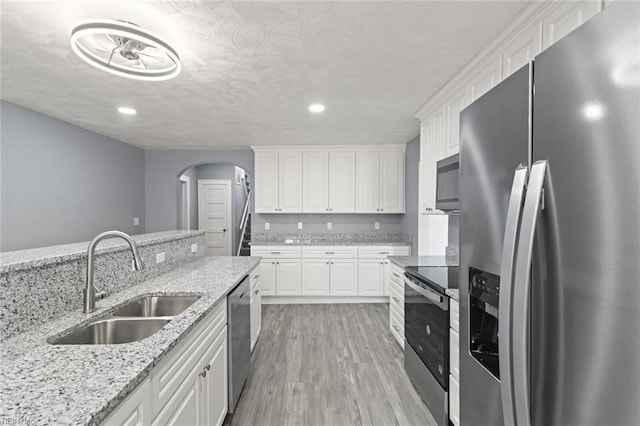 1250 27th St, Newport News, VA 23607 - kitchen with appliances with stainless steel finishes, a sink, arched walkways, white cabinetry, and recessed lighting