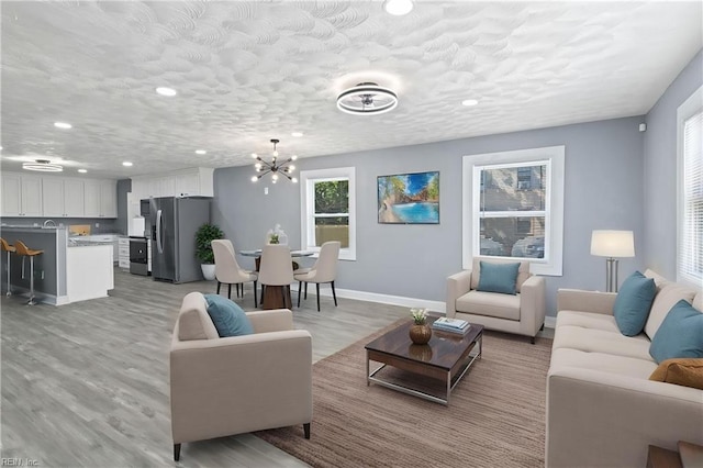 1250 27th St, Newport News, VA 23607 - living room with a chandelier, light wood finished floors, baseboards, and recessed lighting